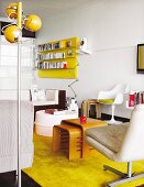 Retromöbeln wie der Tulpenstuhl und der Signal Lampe von Jieldé im Wohnzimmer mit gelber Farbakzent