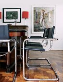Bauhaus cantilever chairs with black leather seats and backs at antique table in traditional living room