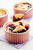 Blackberry clafoutis in ramekins and on a spoon