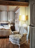 Rustic bedroom with Rococo armchairs, standard lamp and antique, French bed