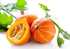 Hokkaido squash, whole and halved, with squash leaves