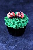 A Halloween cupcake with pumpkin decoration made from marzipan