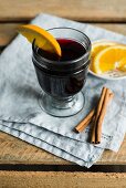 A glass of mulled wine with a slice of orange