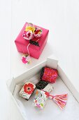 Small gift boxes decorated with tassels and pompoms