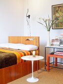 Schlafzimmer mit modernen Doppelbett und Eero Saarinen Beistelltisch