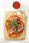 Pizza with dry-cured ham and rocket (view from above)