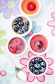 Several mini fruit jellies in eggcups