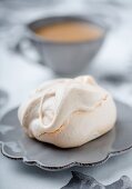 A meringue bite with a cup of coffee
