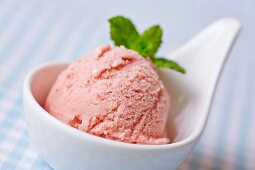 A scoop of home-made raspberry ice cream with mint leaves