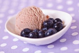 A scoop of home-made blueberry ice cream with fresh blueberries