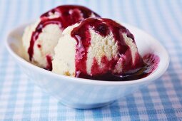 Two fresh scoops of ice cream with home-made blueberry sauce