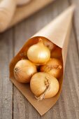 Silverskin onions (whole, with skin) in a paper cone