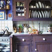 Holzunterschrank und Hängeschränke mit Geschirr in ländlicher Küche
