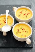 Kürbiscremesuppe mit Curry und roten Pfefferkörnern