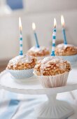 Four muffins with birthday candles