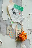 Pinwand mit Briefmarke, Strohblume, bedrucktem Asiapapier und Masking Tape als Wanddeko auf Holz mit extremer Patina