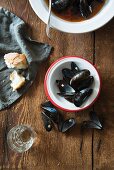 Mussel soup with tomatoes, empty mussel shells and white bread