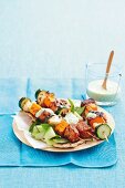 Tandoori chicken skewers with vegetables, served with a yoghurt dip and pita bread
