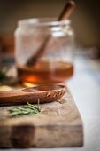 Wooden spoon with honey and a sprig of rosemary