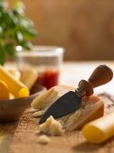 Parmesan mit Käsemesser, Nudeln, Basilikum und Tomatensauce