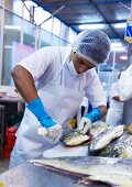 A man preparing fish at a fish market, Peru