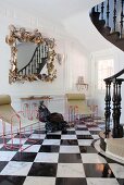 Postmodern, framed mirror and metal chairs with fabric seats in hallway with black and white, chequered marble tiles