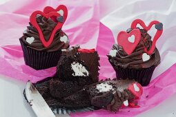 Dunkle Schokoladen-Cupcakes mit roten Herzen, gefüllt mit Buttermilch-Zuckerguss