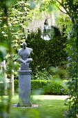 Modern sculpture on plinth in landscaped garden