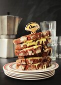 A stack of melted cheese rye bread sandwiches in a retro diner setting