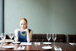 Young woman in restaurant, hands on chin