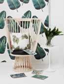 Designer reading chair with cushions against jungle-patterned wallpaper