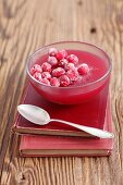 Cranberry jelly with candied cranberries on a stack of books