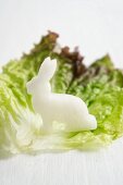 A radish rabbit on a lettuce leaf