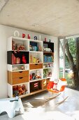 Shelving unit and designer rocking chair in purist, child's bedroom