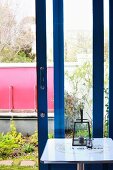 Lantern on small, square table in front of open terrace door