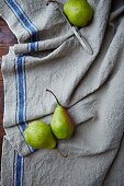 Three pears and a knife on a linen cloth