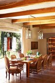 Rattan chairs in dining area in rustic interior with open terrace door and view of garden