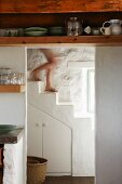 Blick von der Küche in weisses Treppenhaus mit massangefertigtem Untertreppenschrank