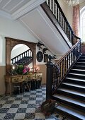 Stairwell of manor house with terrazzo floor and staircase with turned wooden balusters