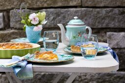 Apricot cake and vintage china crockery on coffee table on terrace