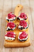 Crackers with goat's cheese, caramelised red onions and black sesame seeds