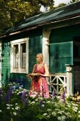 Blonde woman outside wooden house in Sweden