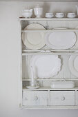 Servierplatten und Geschirr in einem weiß gestrichenen Tellerregal