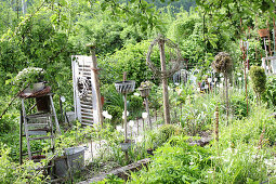 Cottage garden decorated with bric-a-brac and ornamental garden stakes