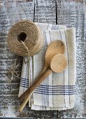 Rustic kitchen utensils: linen dish towel, twine and wooden spoon