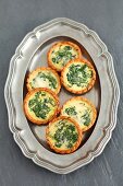 Spinach tartlets on a silver tray (view from above)