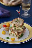 A Stacked Sandwich with Salmon, Avocado, Eggs and Yellow Tomatoes