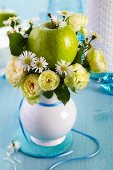 Vase of Blanchette roses, chamomile and a green apple