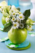 Grüner Apfel als Vase für Blumen