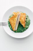 Cheese and ham toasted sandwich on a bed of creamed spinach